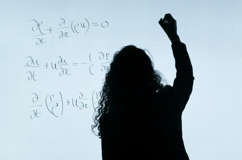Photo of someone drawing formulas on a whiteboard